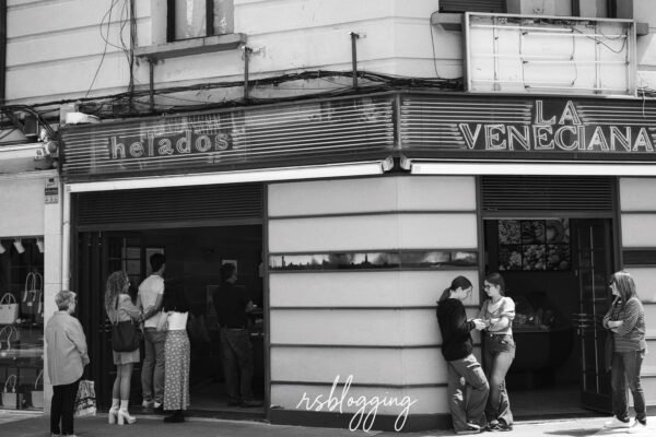 Personas haciendo cola y conversando frente a la heladería La Veneciana en Logroño, en una escena urbana cotidiana.