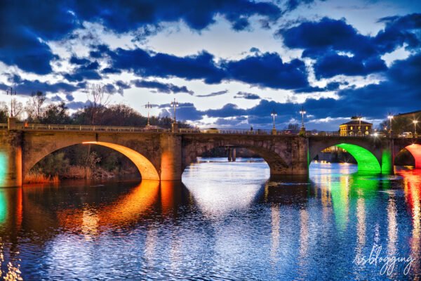 Puente de Piedra de Logroño reflejado en el río Ebro con luces de colores al anochecer